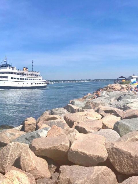 ocean view of boats coming in and out of Point Judith Harbor with kids